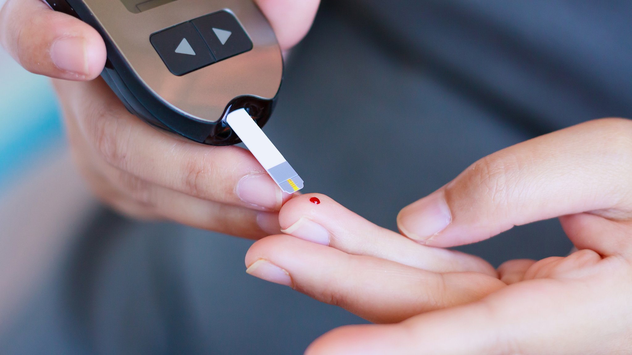 Eine Person misst ihren Blutzucker mit einem Glucosetest für Diabetiker.