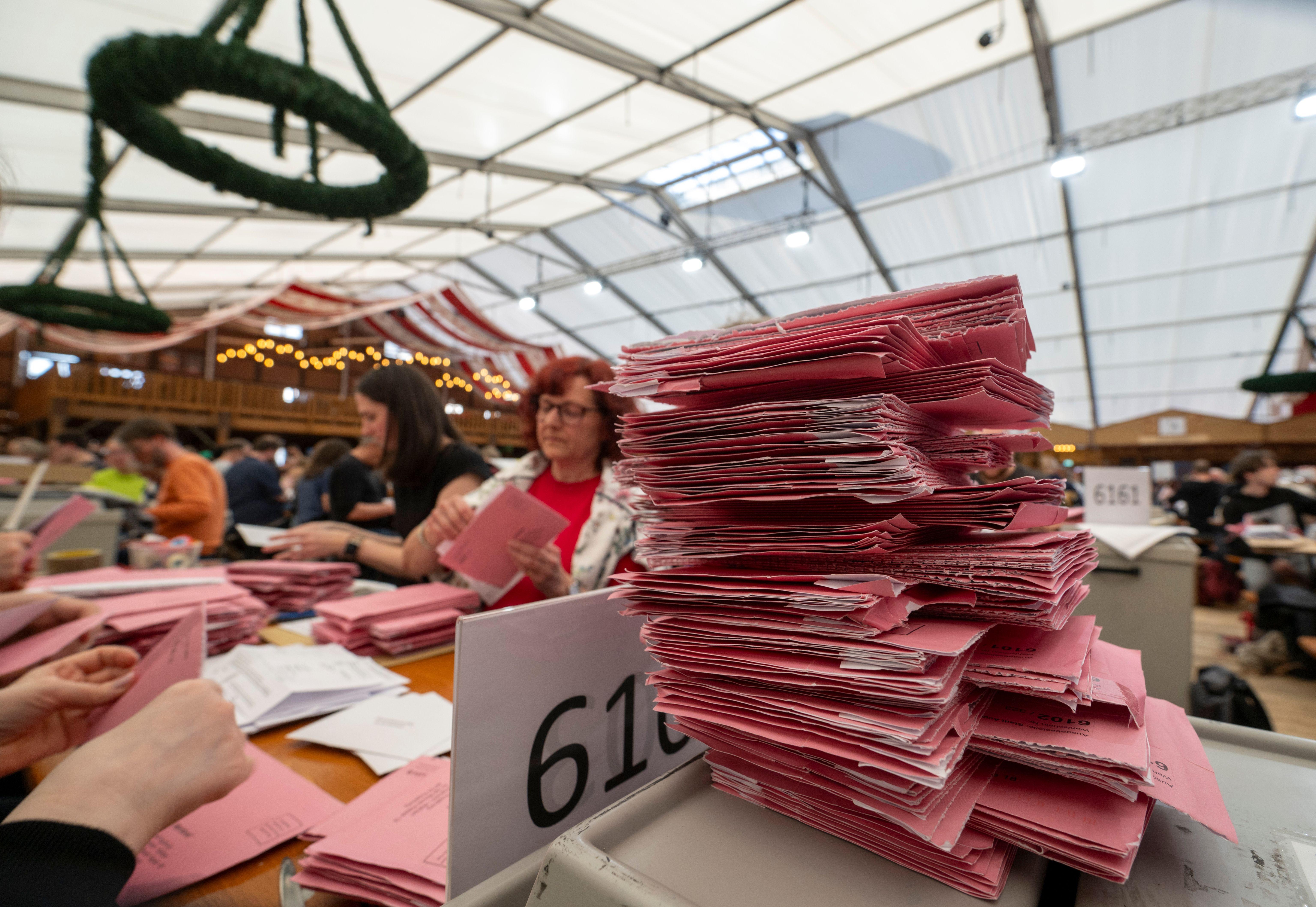 In Augsburg sortieren Wahlhelfer in einem Bierzelt Briefwahlunterlagen zur Stichwahl der Kommunalwahl..