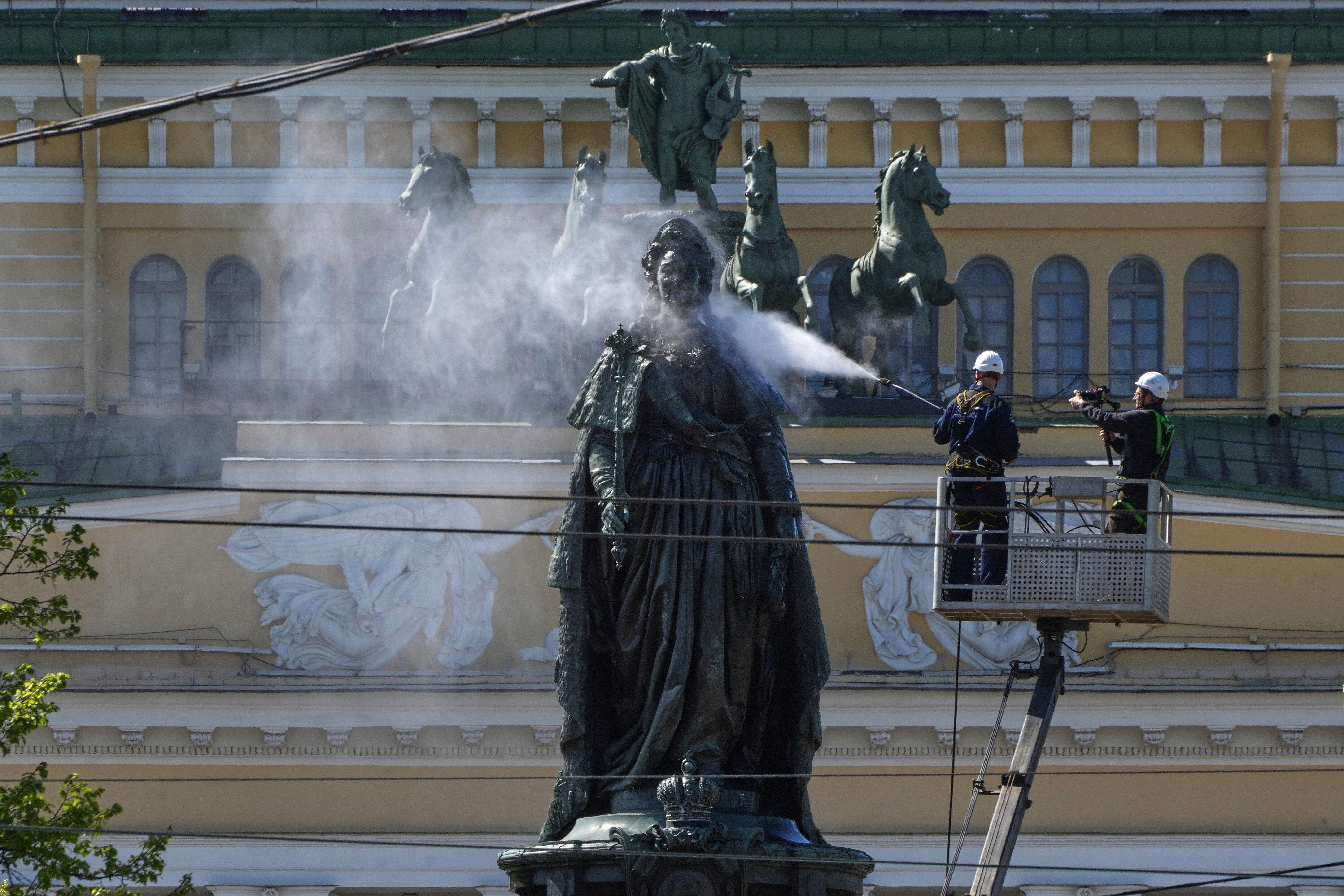 Arbeiter säubern ein Denkmal von Katharina II.