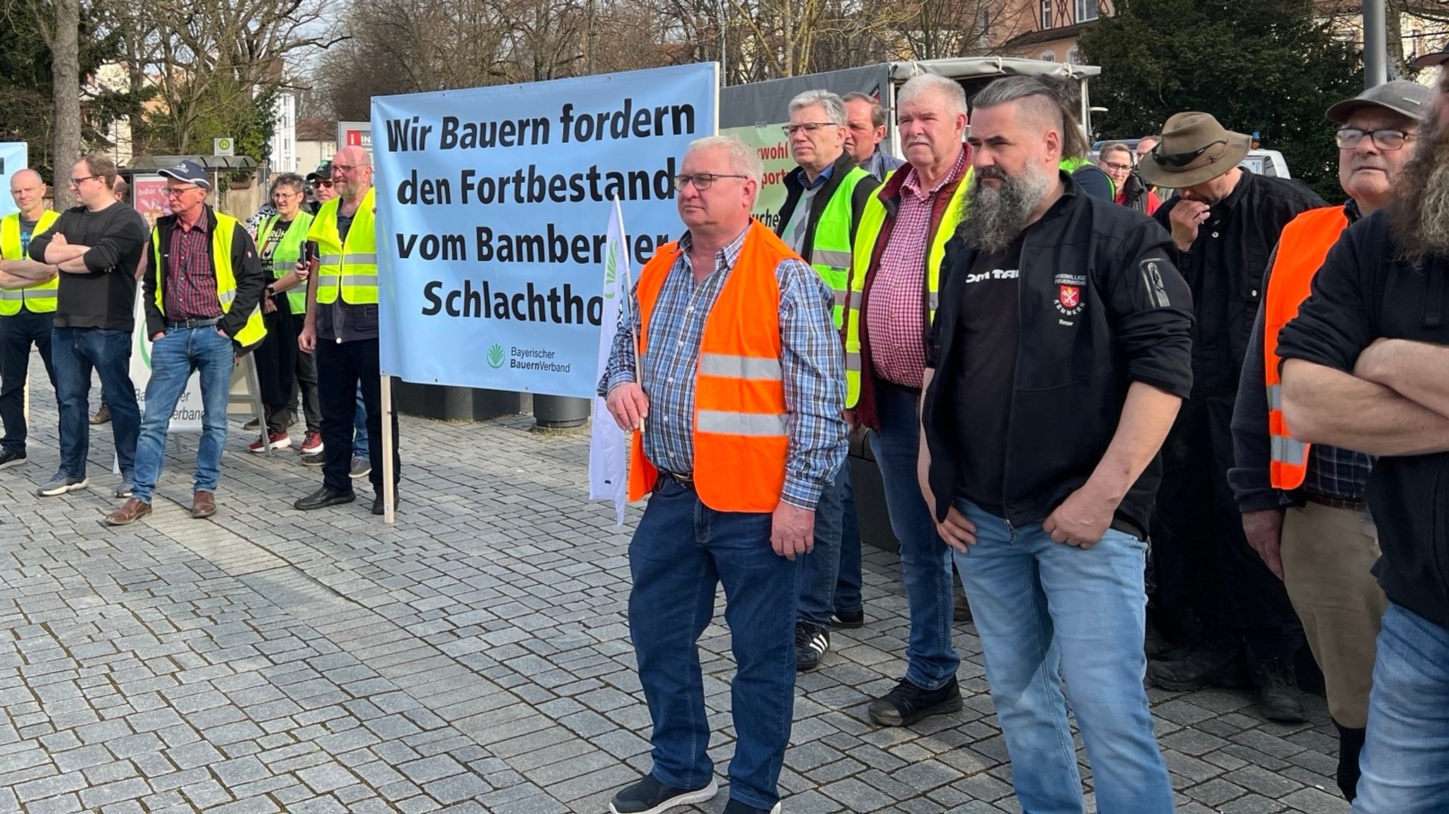 Landwirte halten Transparente in den Händen, auf denen sie den Fortbestand des Bamberger Schlachthofs fordern. 