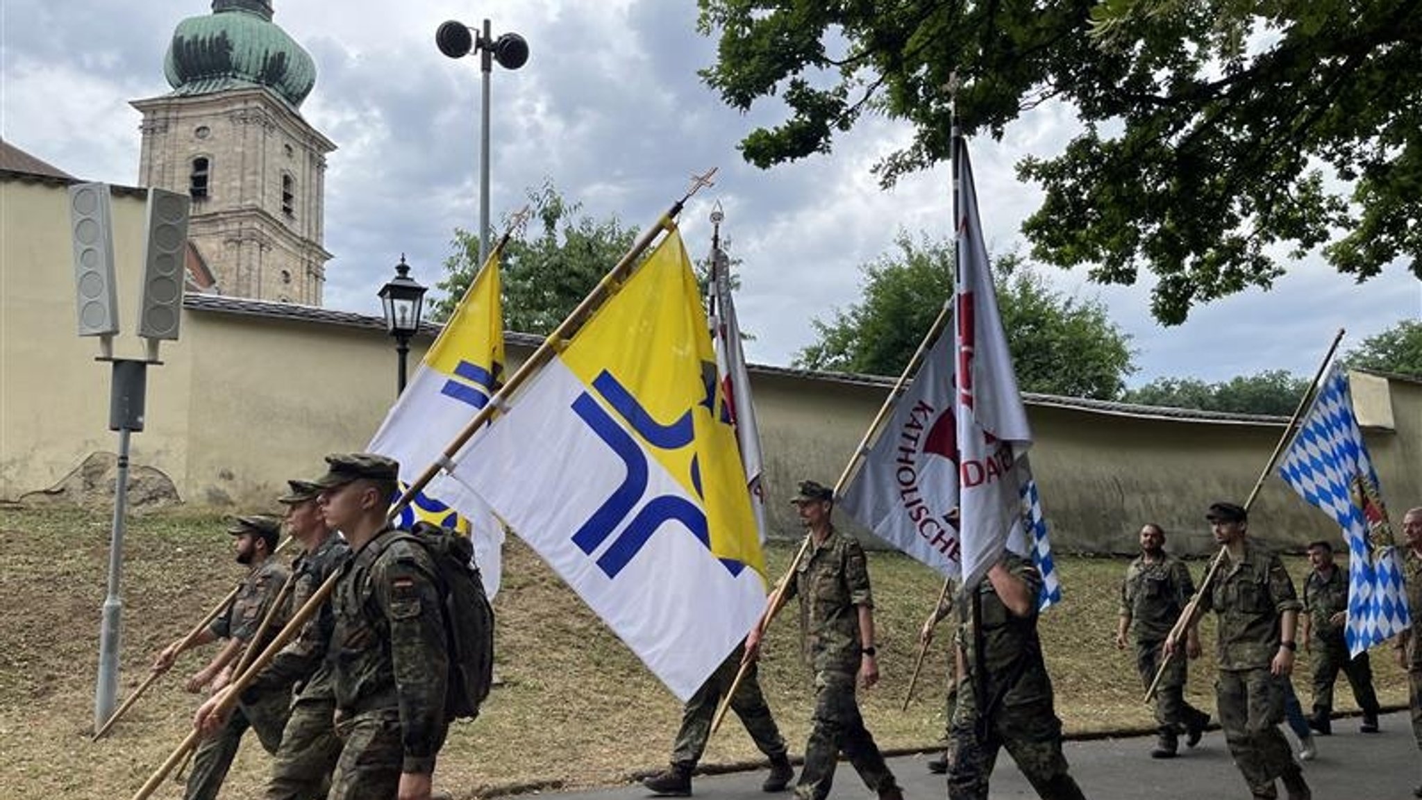 Soldaten pilgern in Amberg auf den Mariahilfberg und tragen teilweise Fahnen. 