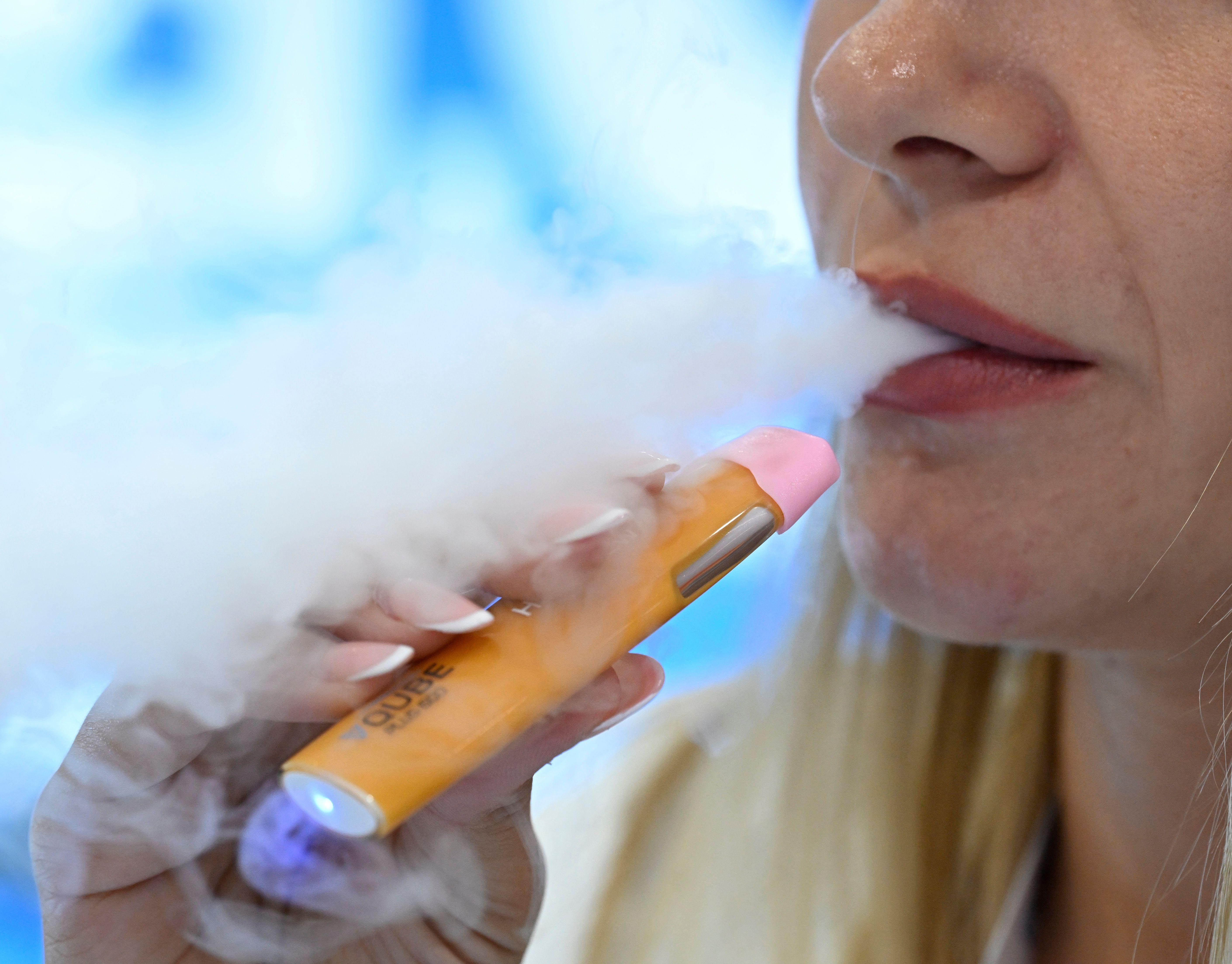 Eine Frau inhaliert eine Wegwerf-E-Zigarette (Archivbild).