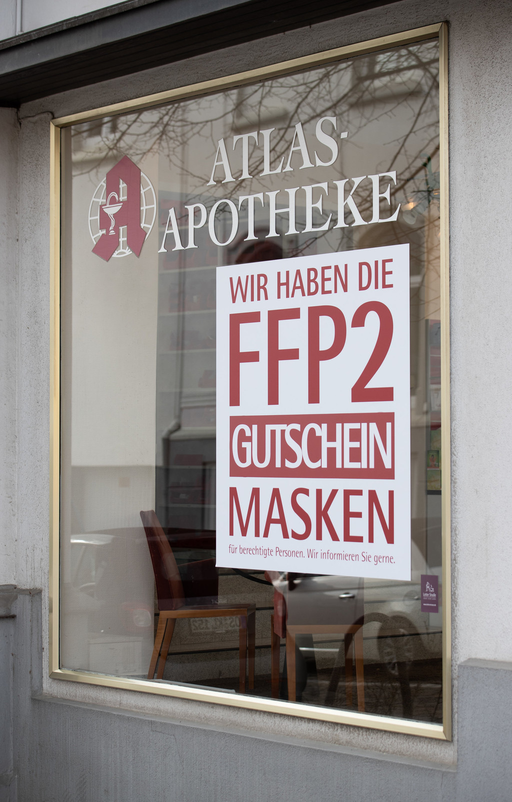 Das Fenster einer Apotheke mit dem Plakat für FFP2-Masken