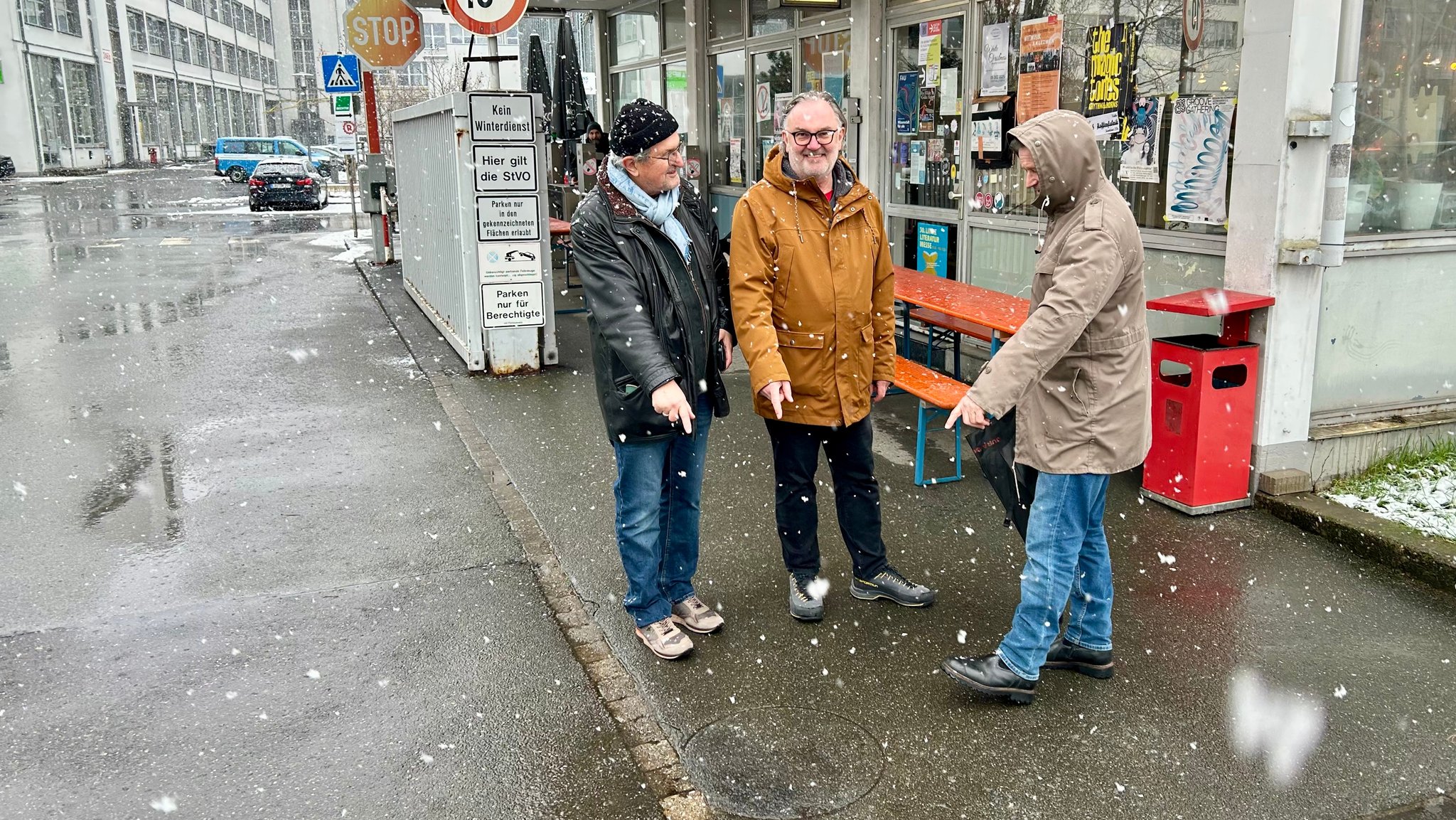 Der frühere AEG-Betriebsratsvorsitzende, Harald Dix, sowie der ehemalige IG-Bevollmächtigte für die AEG, Jürgen Wechsler, zeigen auf einen Kreis im Asphalt vor dem AEG-Werkstor. Es ist der Abdruck einer Feuertonne, die während des Streiks im Winter 2006 gebrannt haben.