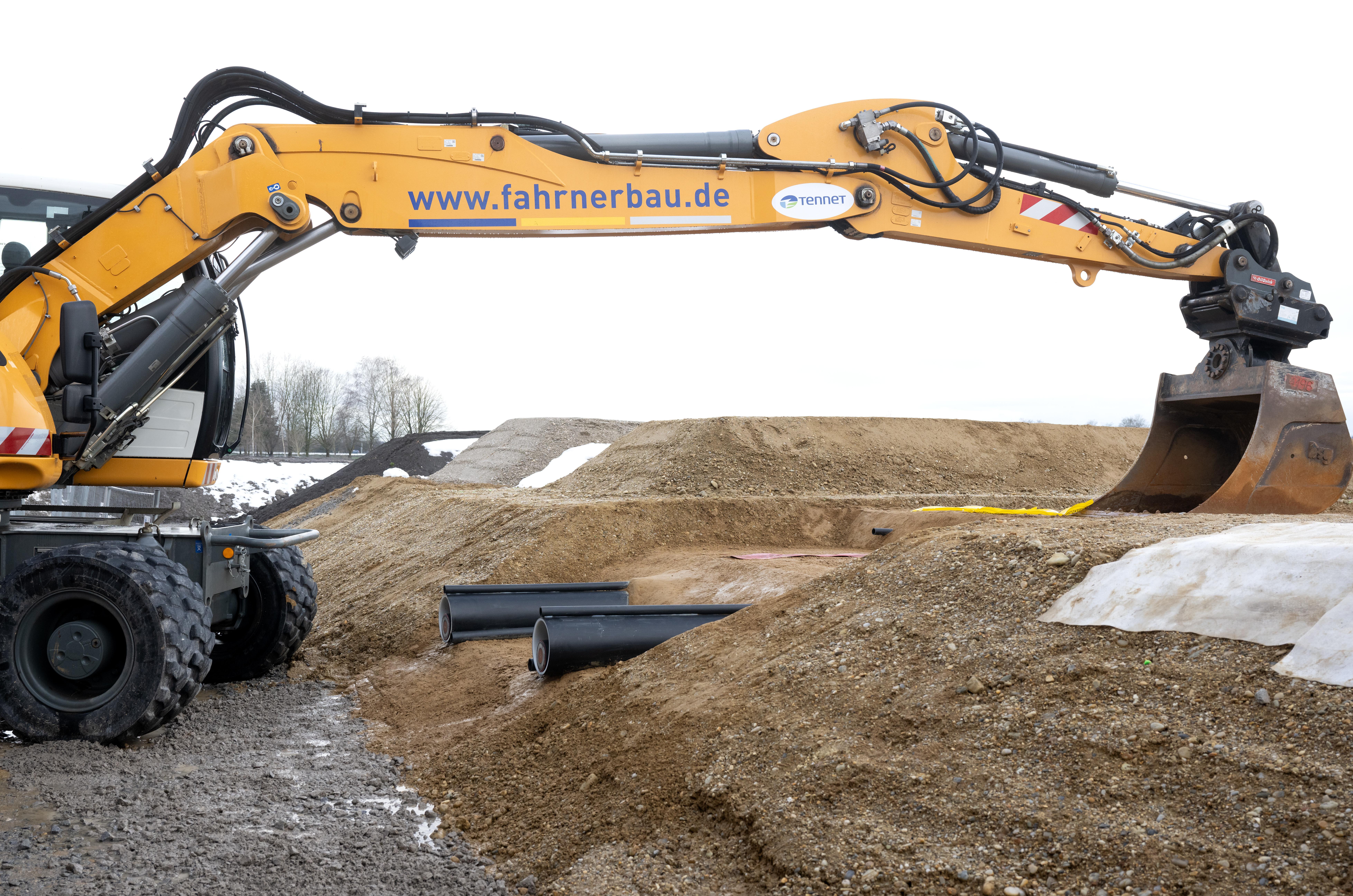 Ein Bagger und zwei Kabel sind während der symbolischen Baustelleneröffnung für die Baumaßnahmen des Südostlinks zu sehen.