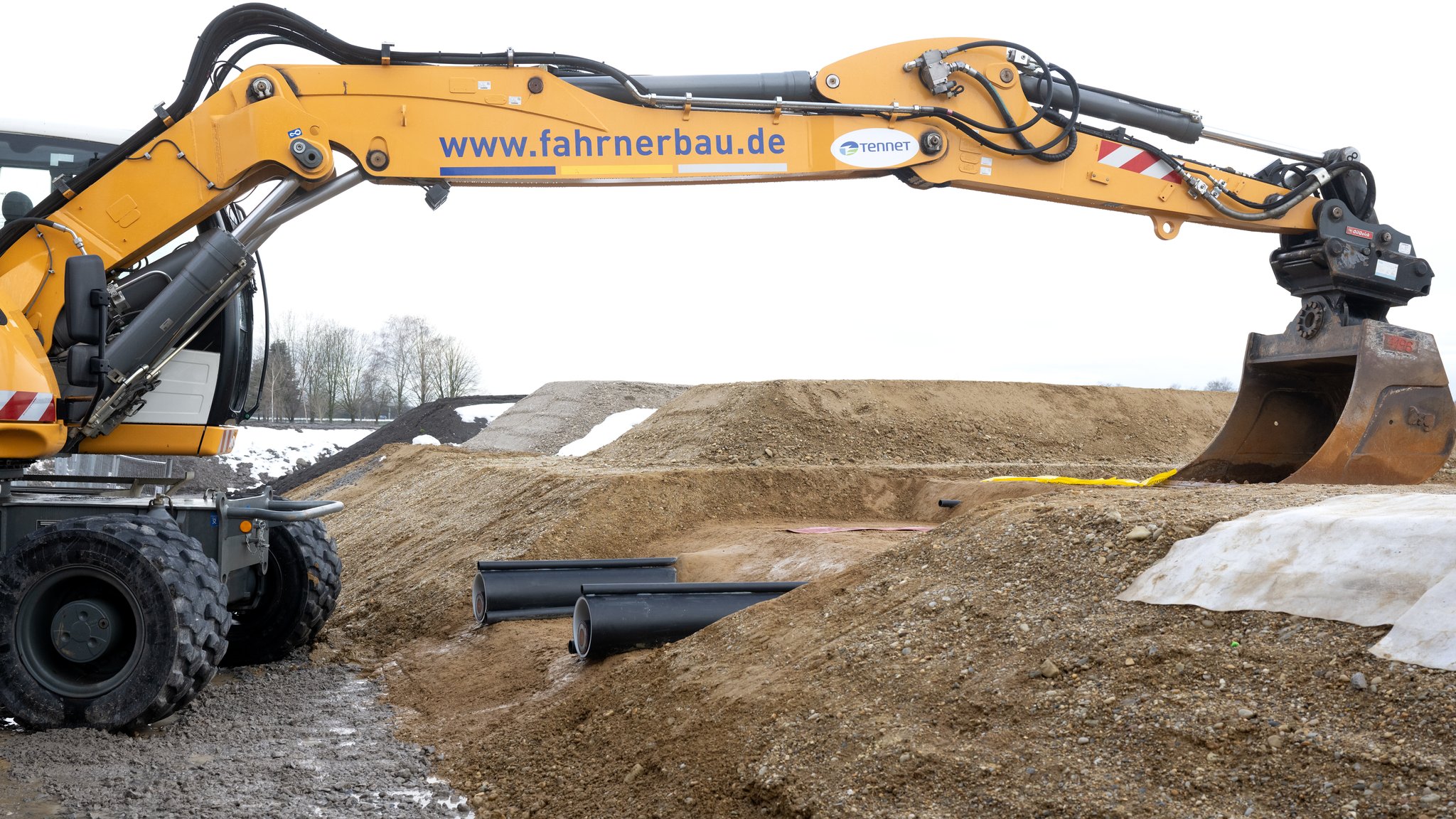 Ein Bagger und zwei Kabel sind während der symbolischen Baustelleneröffnung für die Baumaßnahmen des Südostlinks zu sehen.