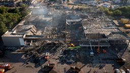 Feuerwehrleute des Staatlichen Katastrophenschutzes beseitigen die Trümmer eines Einkaufszentrums, das nach einem Raketenangriff in Brand geraten ist. | Bild:dpa-Bildfunk/Efrem Lukatsky