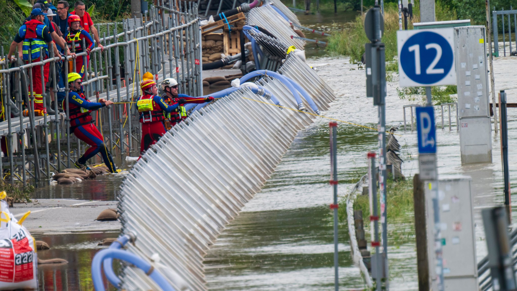 Regensburg, 06.06.24: Mitarbeiter der Wasserwacht kontrollieren die provisorischen Schutzwände an der Donau in der Altstadt.