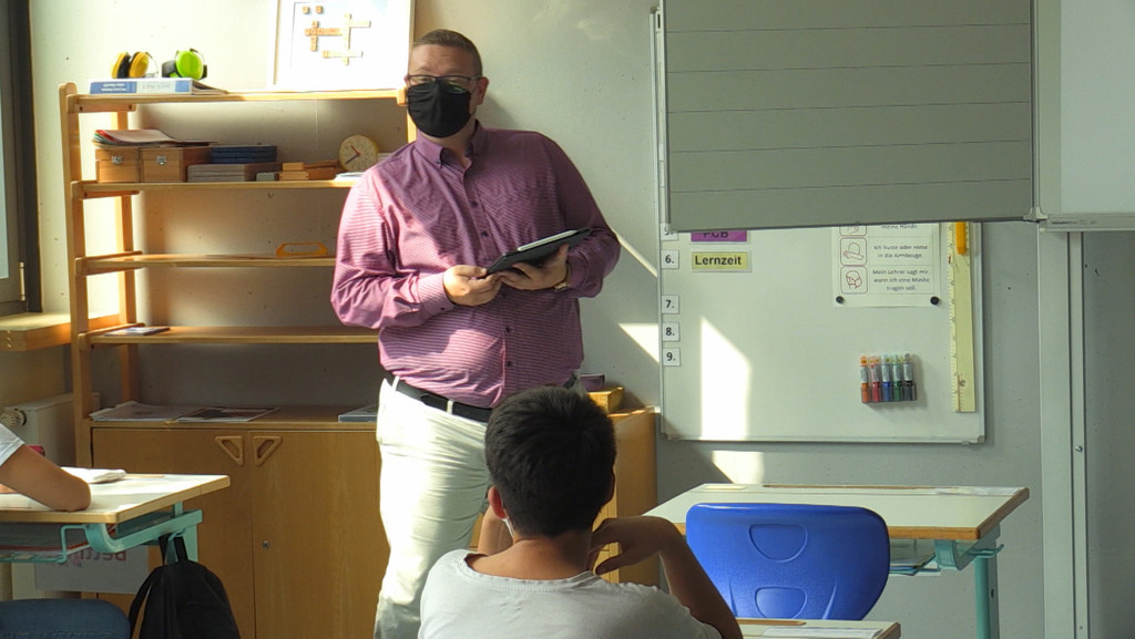 Lehrer unterrichtet mit Maske