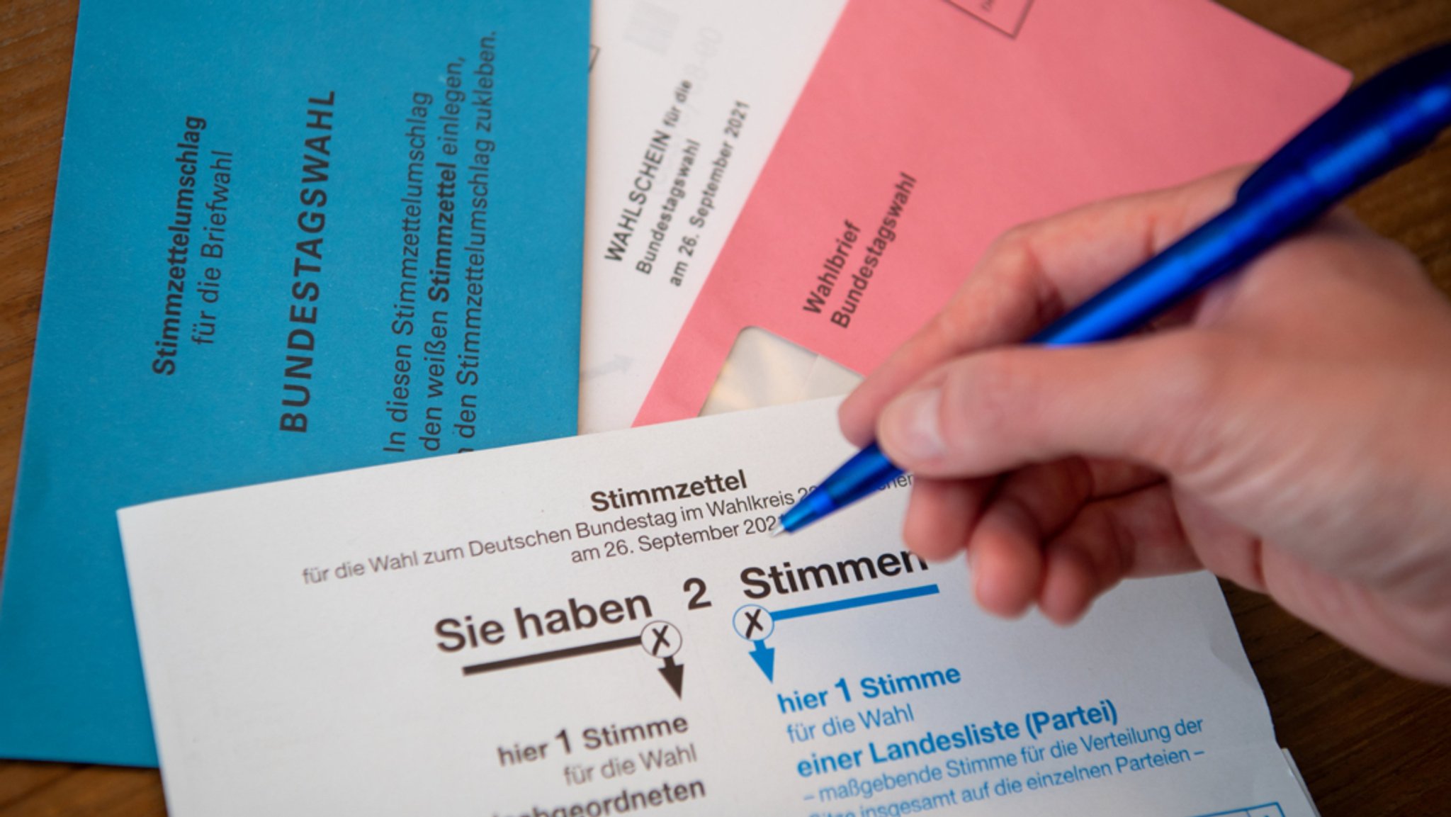 Briefwahlunterlagen für die Bundestagswahl 2021 mit Stimmzettel und Stimmzettelumschlag liegen auf einem Tisch.