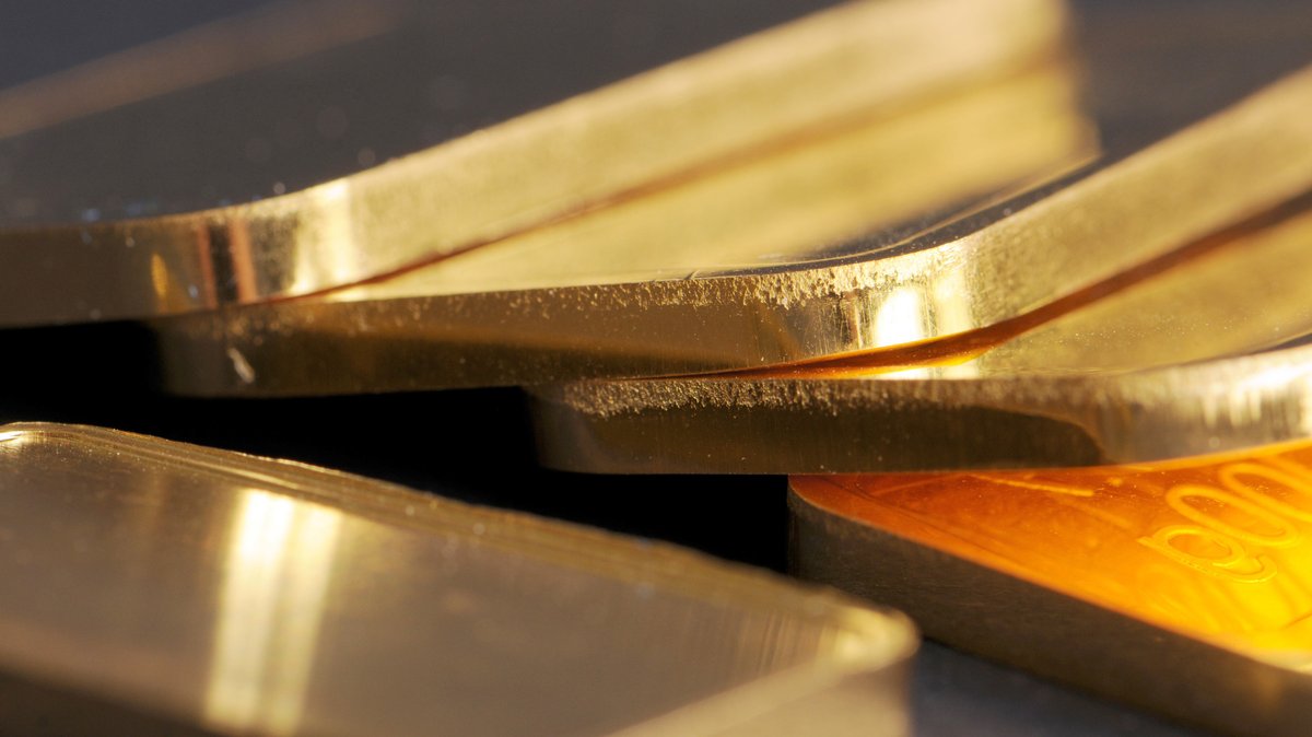 Goldbarren (100 Gramm) liegen auf einem Tisch. 