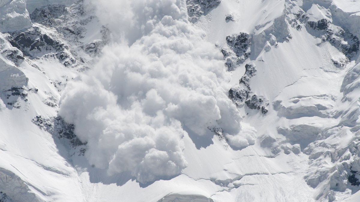 Eine Schneelawine rast einen Berg hinunter