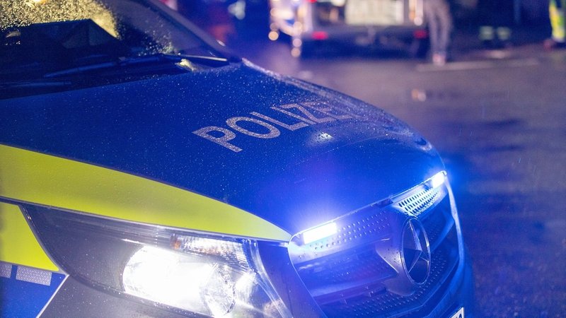 Ein Polizeiwagen mit Blaulicht bei Dunkelheit (Symbolbild)