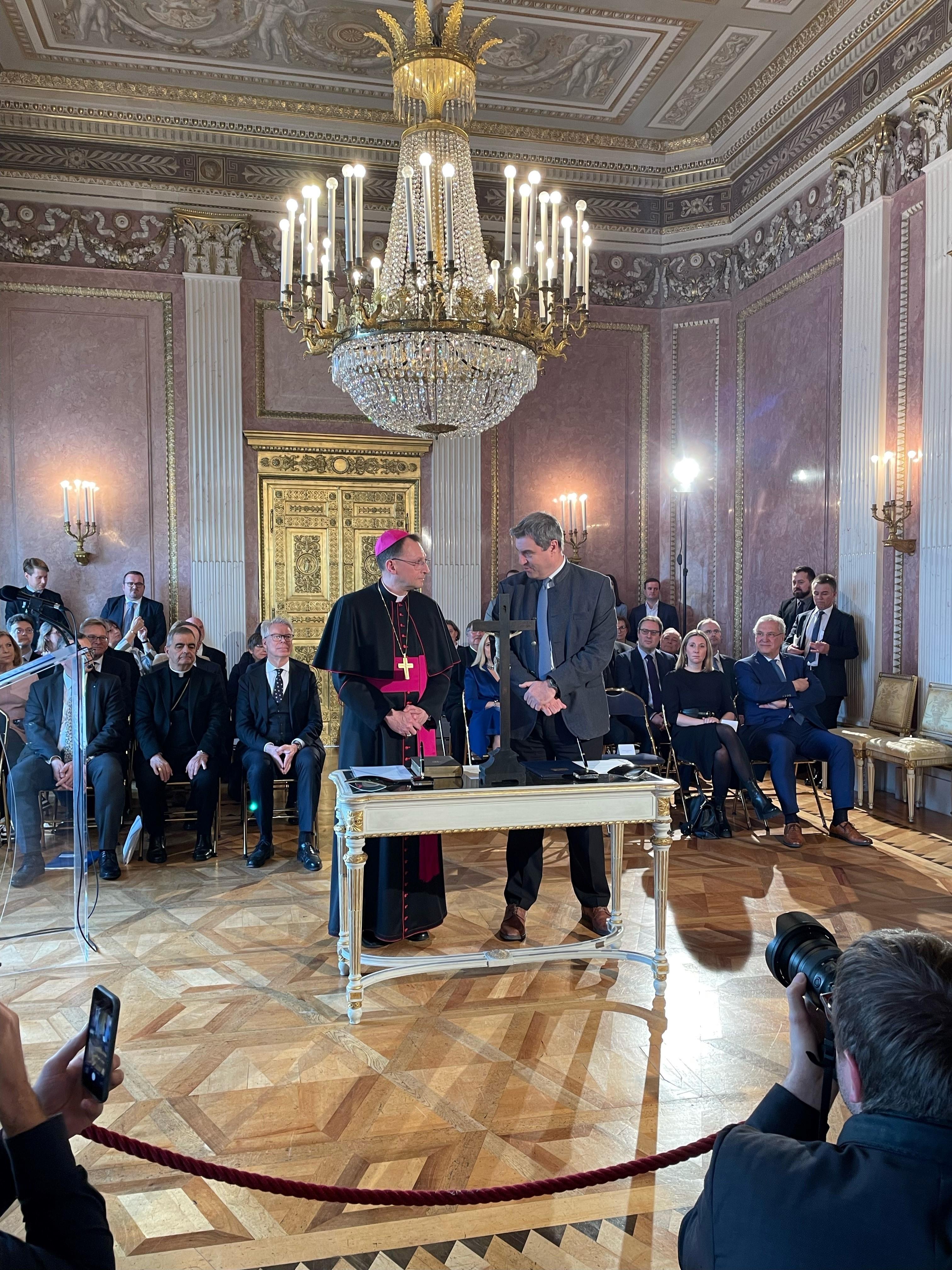 Erzbischof und Ministerpräsident schütteln sich die Hände.