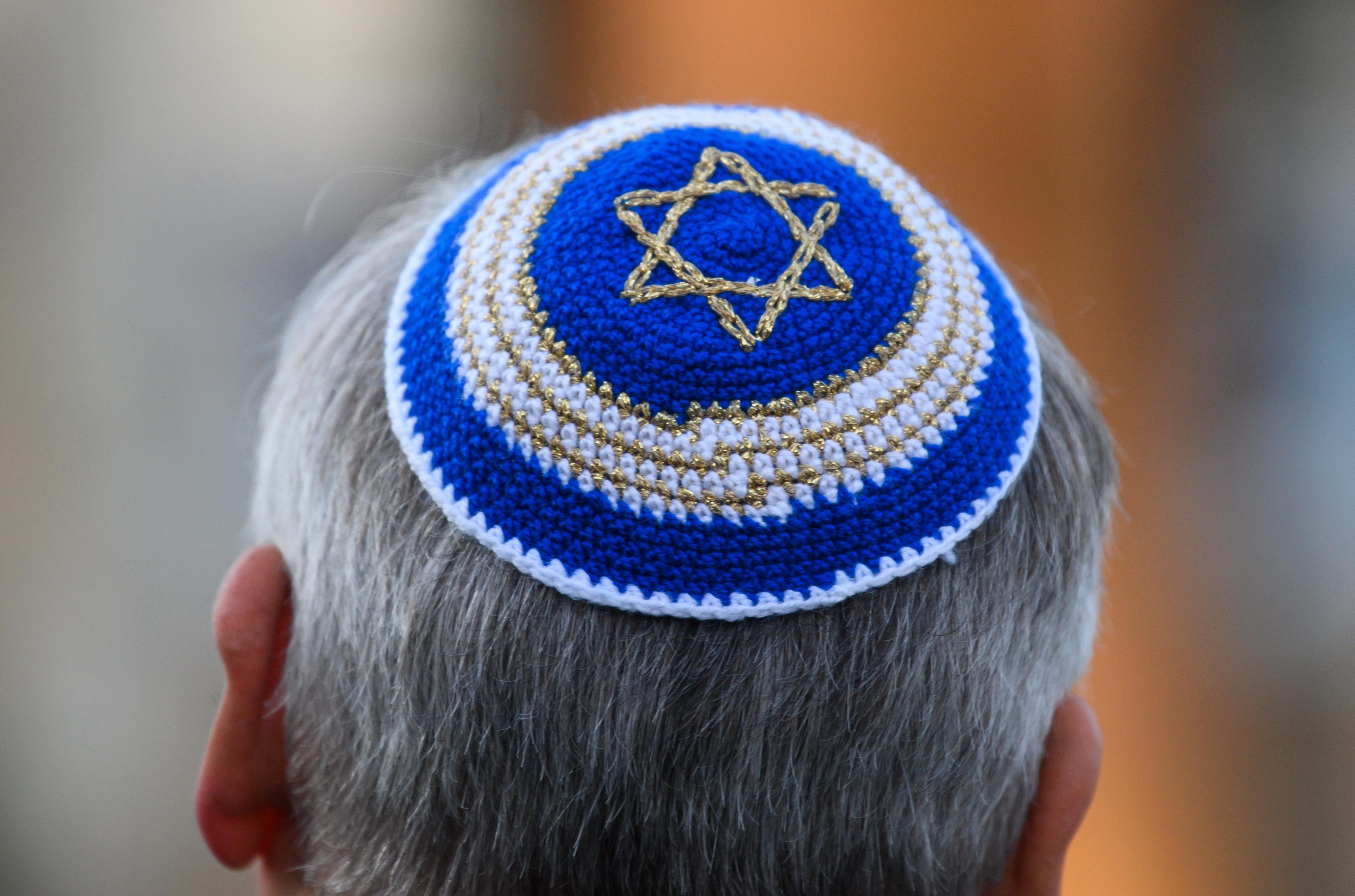 Ein Mann trägt im Rahmen einer Kranzniederlegung vor der Synagoge eine Kippa mit Judenstern. Die Stadt gedenkt der Opfer der Opfer der Pogromnacht vom 9. November 1938 und die Jüdische Gemeinde feiert 20 Jahre Weihe der Neuen Synagoge Dresden. | Bild:picture alliance/dpa/dpa-Zentralbild | Robert Michael