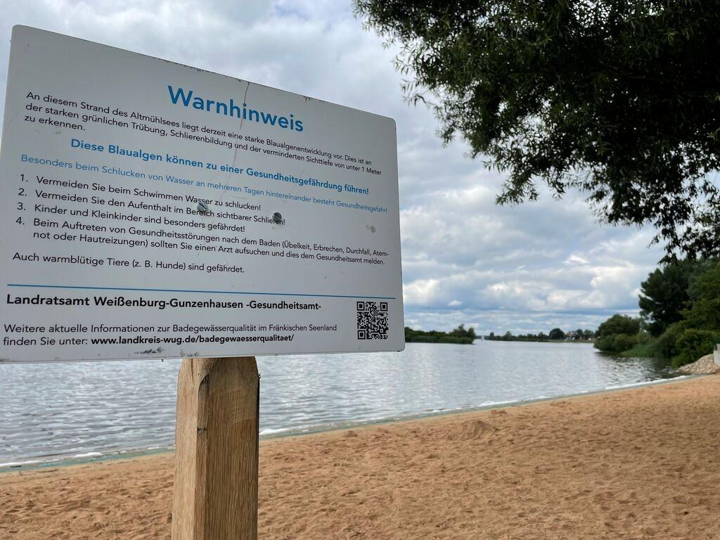 Warnschild am See. Für die Altmühlsee-Strände in Schlungenhof und Muhr am See ist eine Badewarnung ausgesprochen worden. Das Gesundheitsamt des Landratsamtes Weißenburg-Gunzenhausen hat an beiden Stellen reichlich Blaualgen festgestellt. Blaualgen können Übelkeit, Erbrechen und Durchfall auslösen.