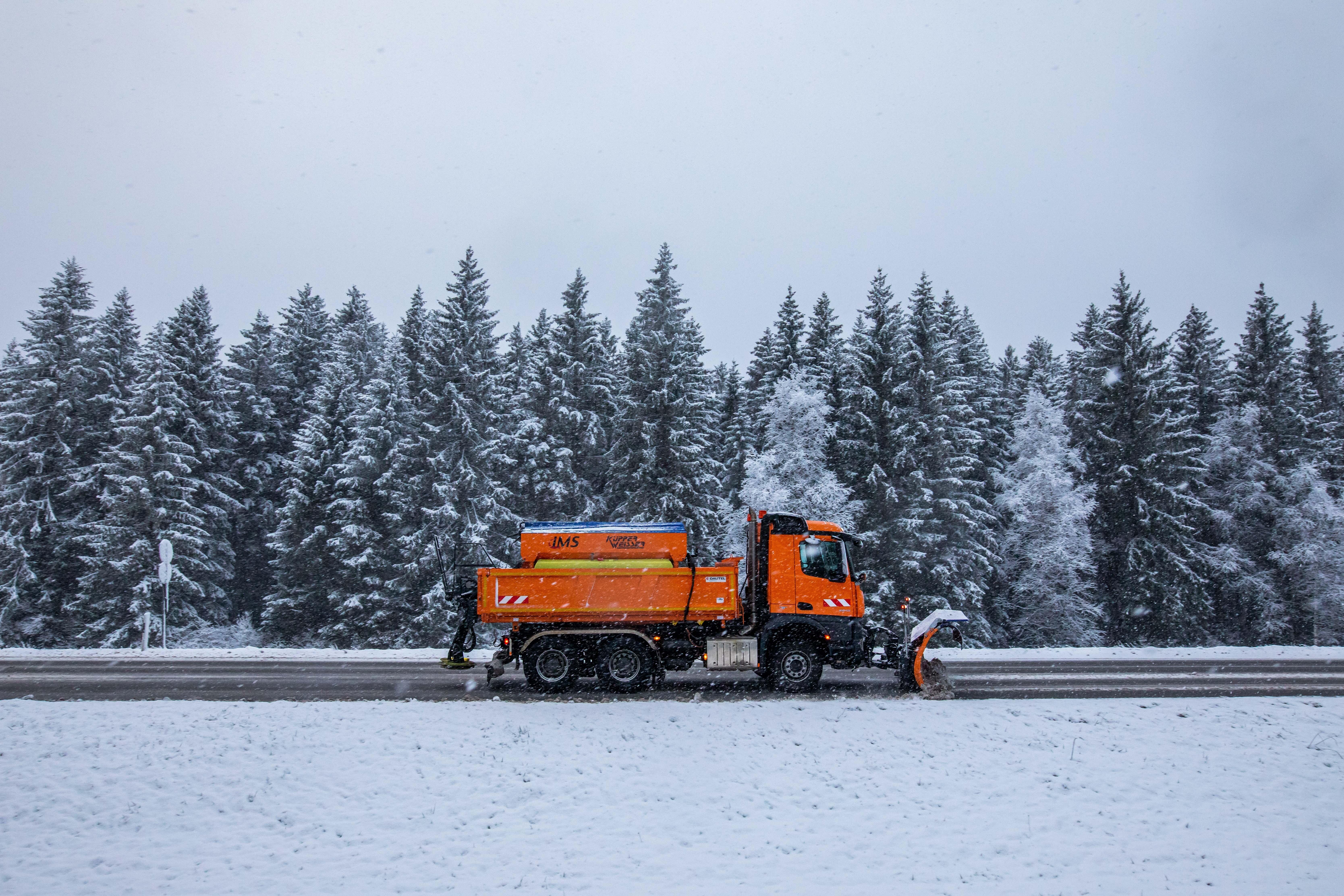 Winterdienst auf einer Bundesstraße an einem Waldrand