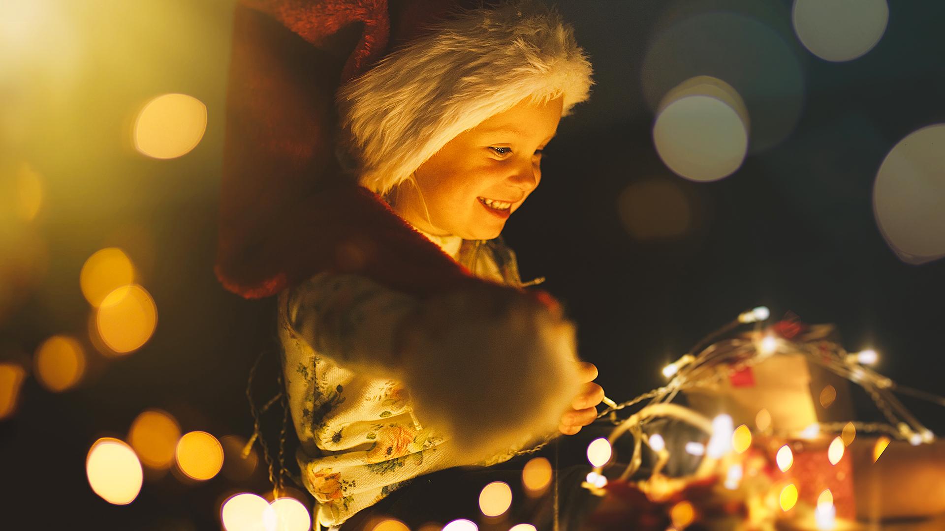 Kind freut sich über glitzernde Weihnachtsbeleuchtung