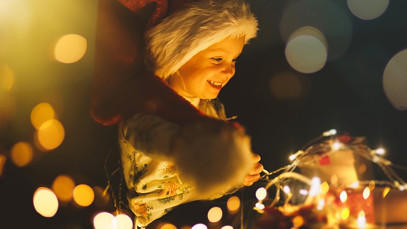 Kind freut sich über glitzernde Weihnachtsbeleuchtung