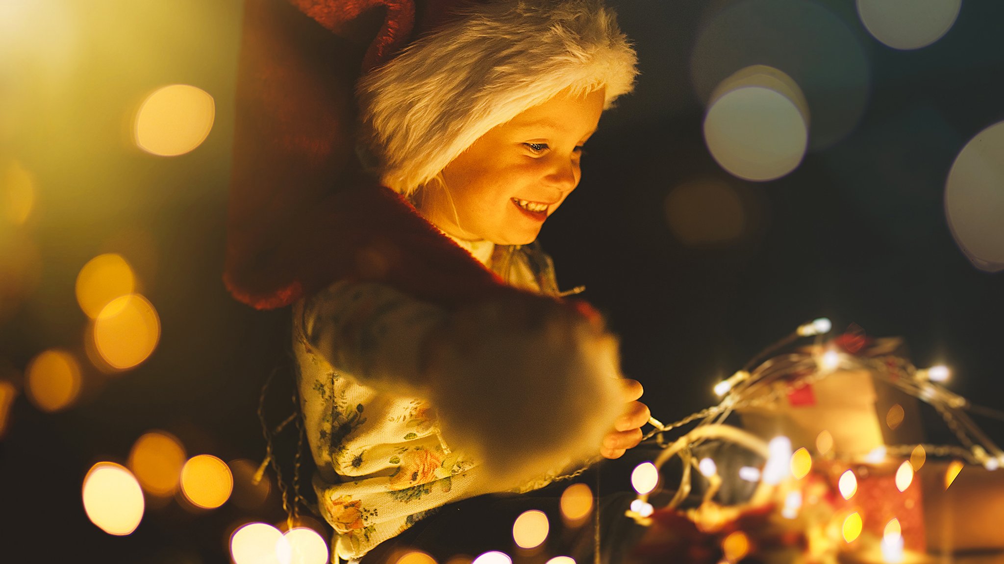 Kind freut sich über glitzernde Weihnachtsbeleuchtung