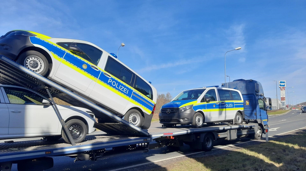 Zwei Berliner Polizeifahrzeuge auf einem polnischen Transportauflieger.
