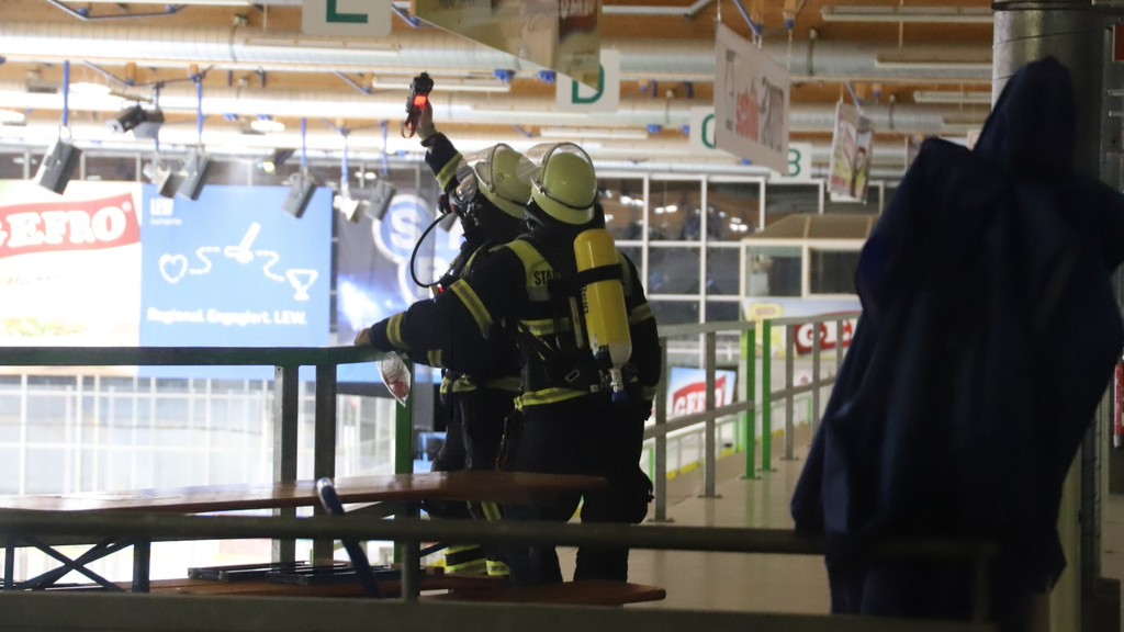 Feuerwehrmänner mit Messgerät in der Eishalle