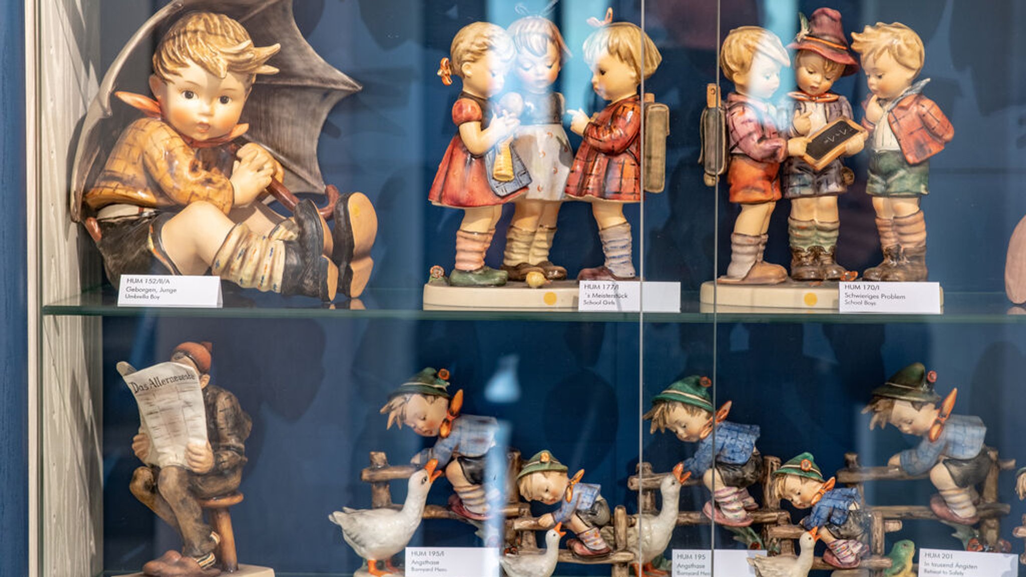 Hummel-Porzellanfiguren stehen in einer Vitrine 