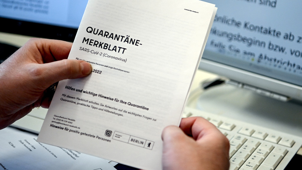 Ein Mitarbeiter eines Berliner Gesundheitsamts hält ein Quarantäne-Merkblatt in den Händen (Symbolbild).
