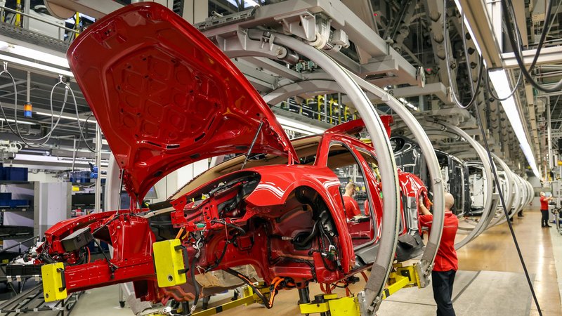 Ein Mitarbeiter montiert Kabelbäume in einem Automobilwerk. | Bild: dpa-Bildfunk/Jan Woitas Ein Mitarbeiter montiert Kabelbäume in einem Automobilwerk.