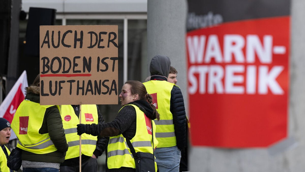 Auch der Boden ist Lufthansa steht auf einem Plakat, mit dem sich eine Frau am Streik beteiligte. 