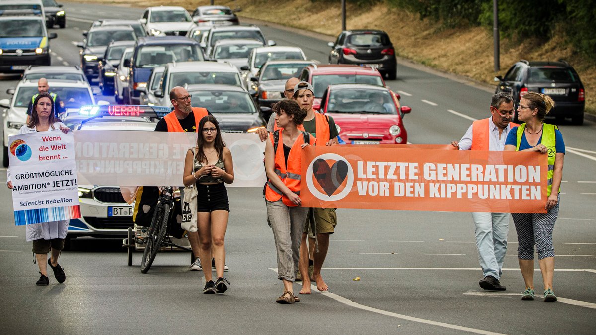 Klima-Aktivisten der "Letzten Generation" laufen in Bayreuth über den Hohenzollernring.