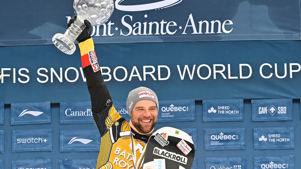 Martin Nörl hält die FIS-Kristallkugel in der Hand, als er beim FIS-Snowboardcross-Weltcup in Beaupre, Quebec, seinen Saisonsieg feiert. 