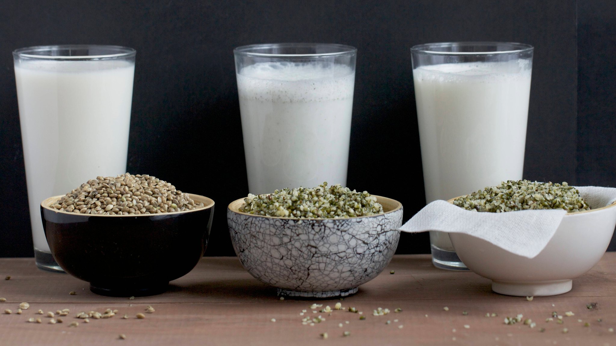 Drei Glas "Milch" mit jeweils einem Schälchen mit Samen davor