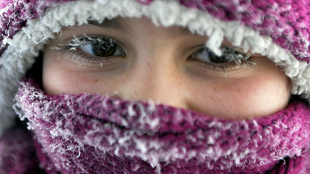 Kind mit Mütze und Schal und gefrorenen Wimpern
