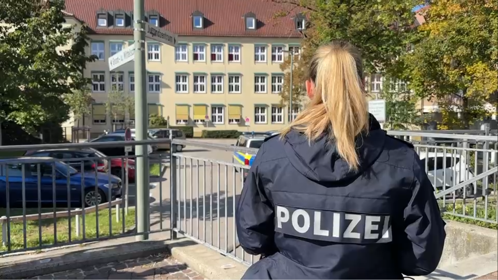 Eine Polizistin schaut auf die Mittelschule in Friedberg.