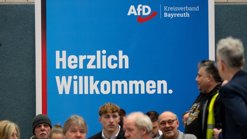 "Herzlich Willkommen." steht auf einem Plakat der AfD bei einer Wahlveranstaltung in Seybothenreuth im Landkreis Bayreuth. | Bild: pa/dpa/Pia Bayer "Herzlich Willkommen." steht auf einem Plakat der AfD bei einer Wahlveranstaltung in Seybothenreuth im Landkreis Bayreuth.