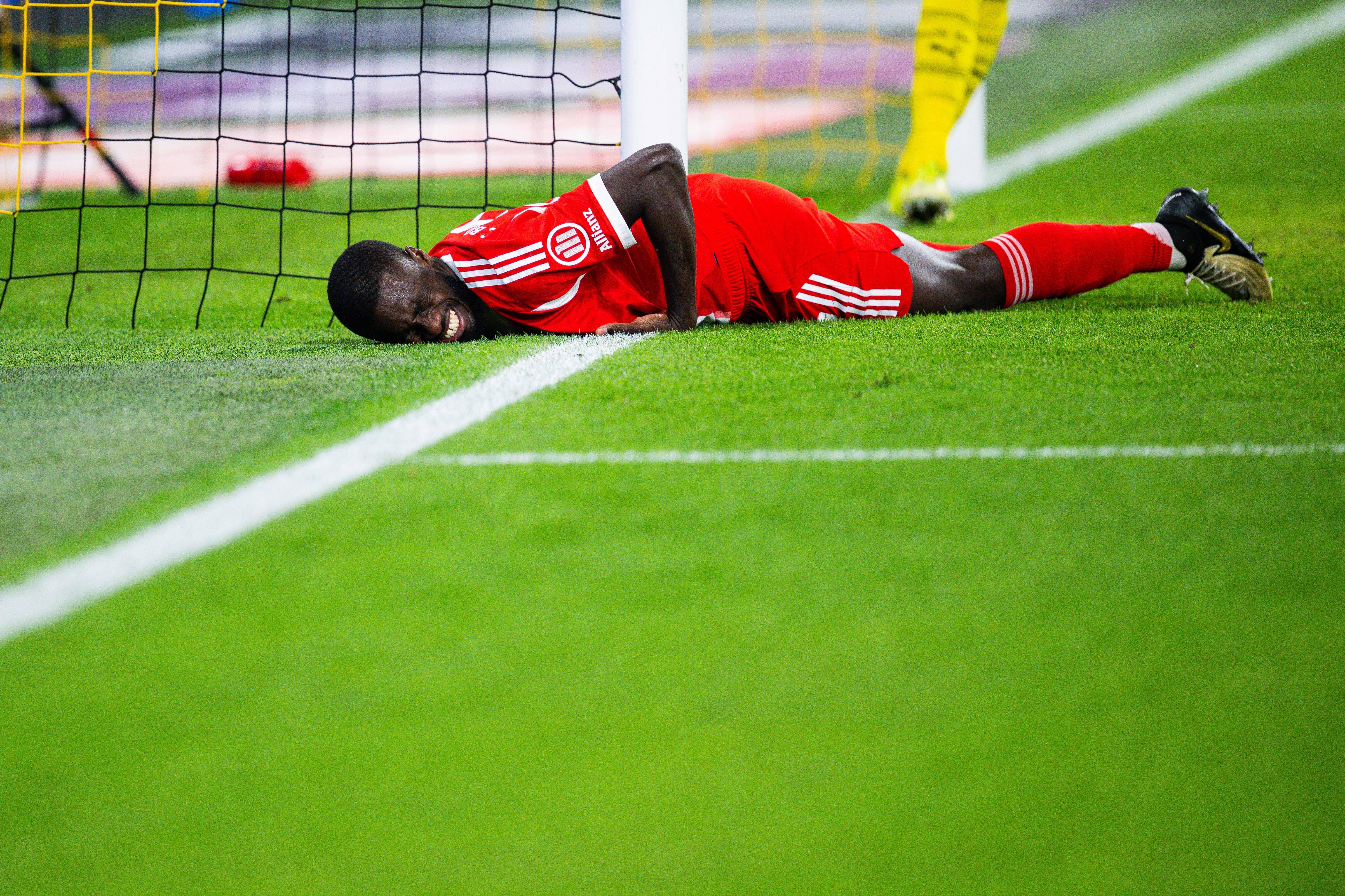 Dayot Upamecano (FC Bayern) liegt auf dem Rasen des Signal Iduna Parks.