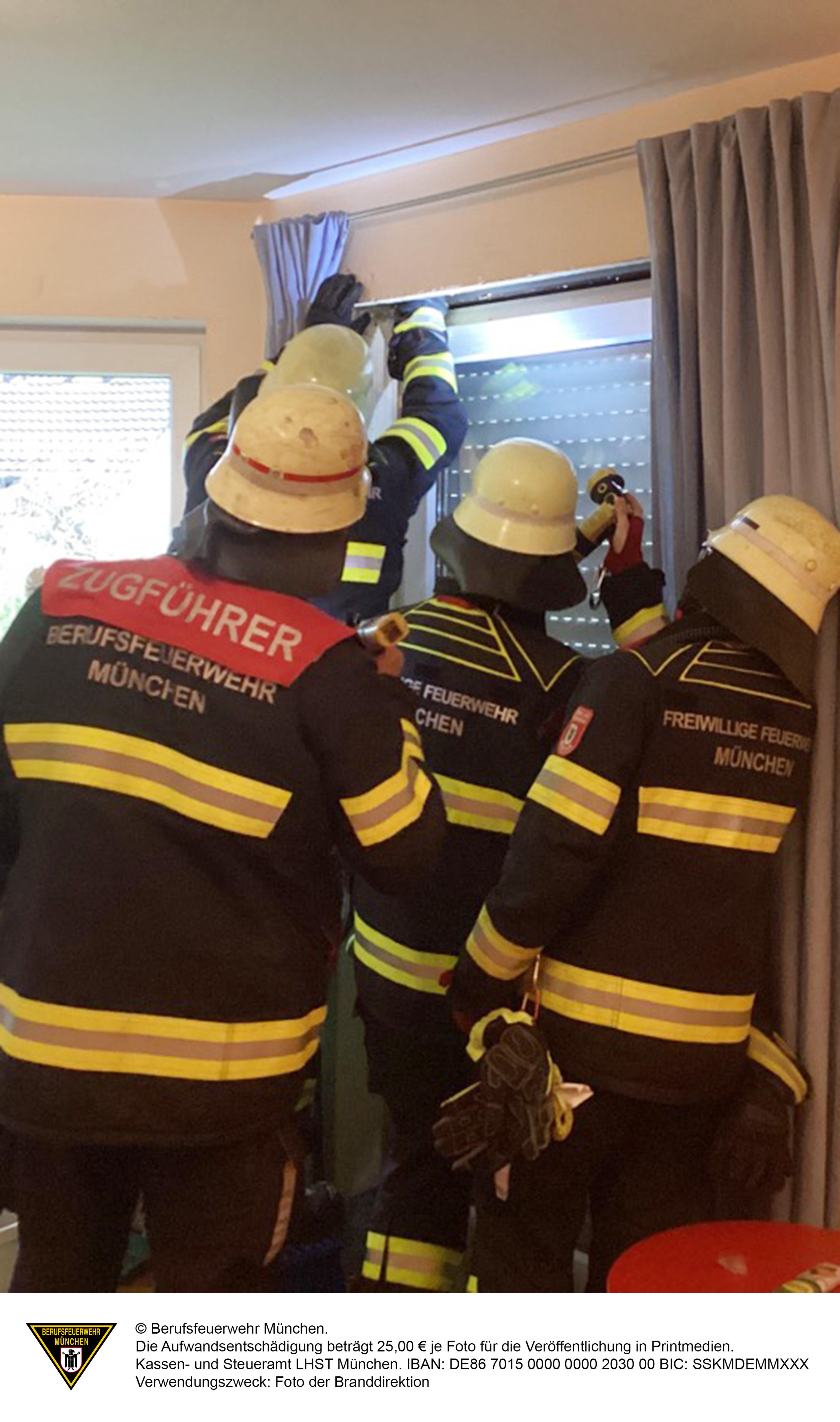 Feuerwehrkräfte überprüfen den Rollladenkasten. | Bild:Berufsfeuerwehr München