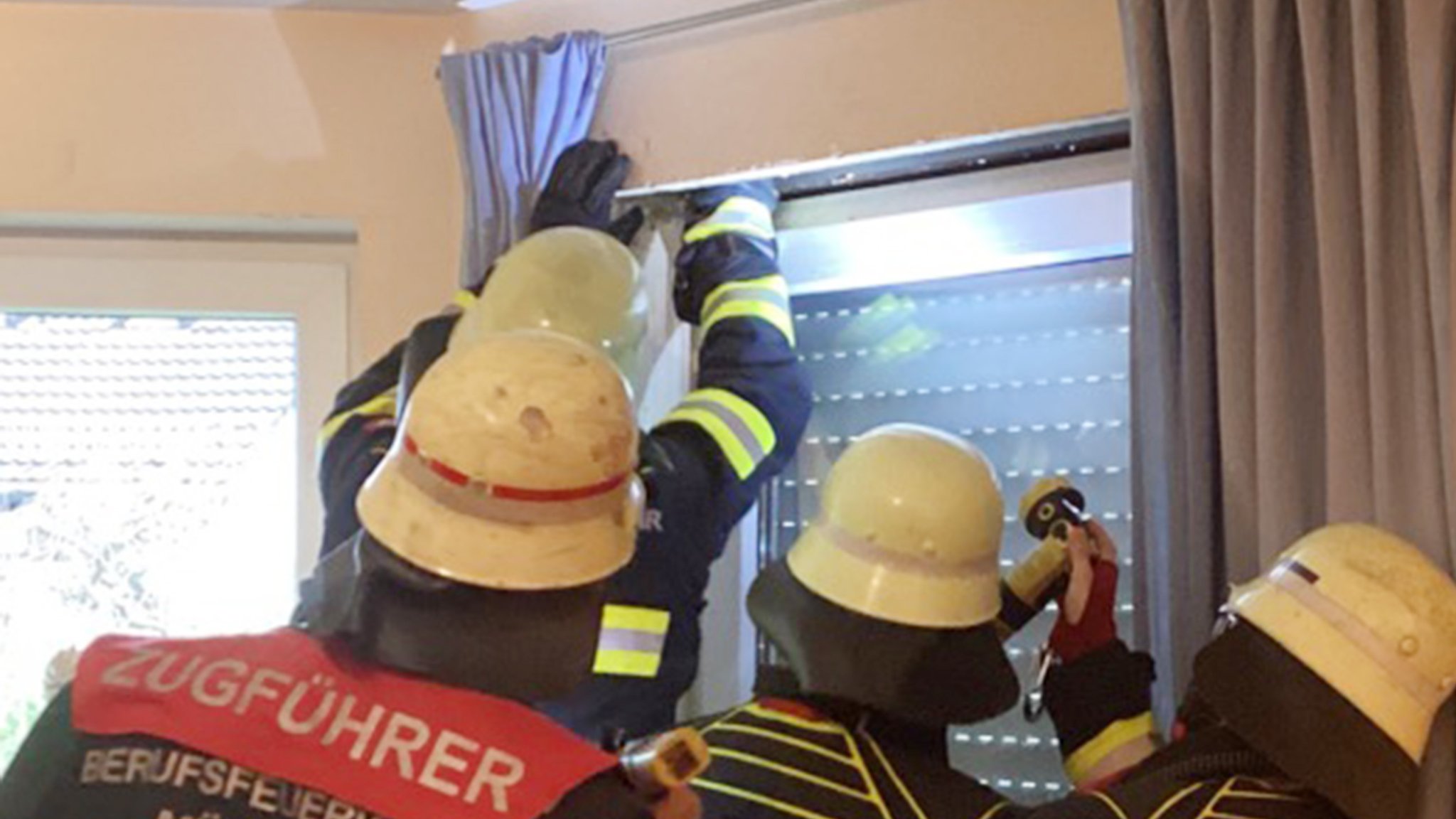 Feuerwehrkräfte überprüfen den Rollladenkasten.