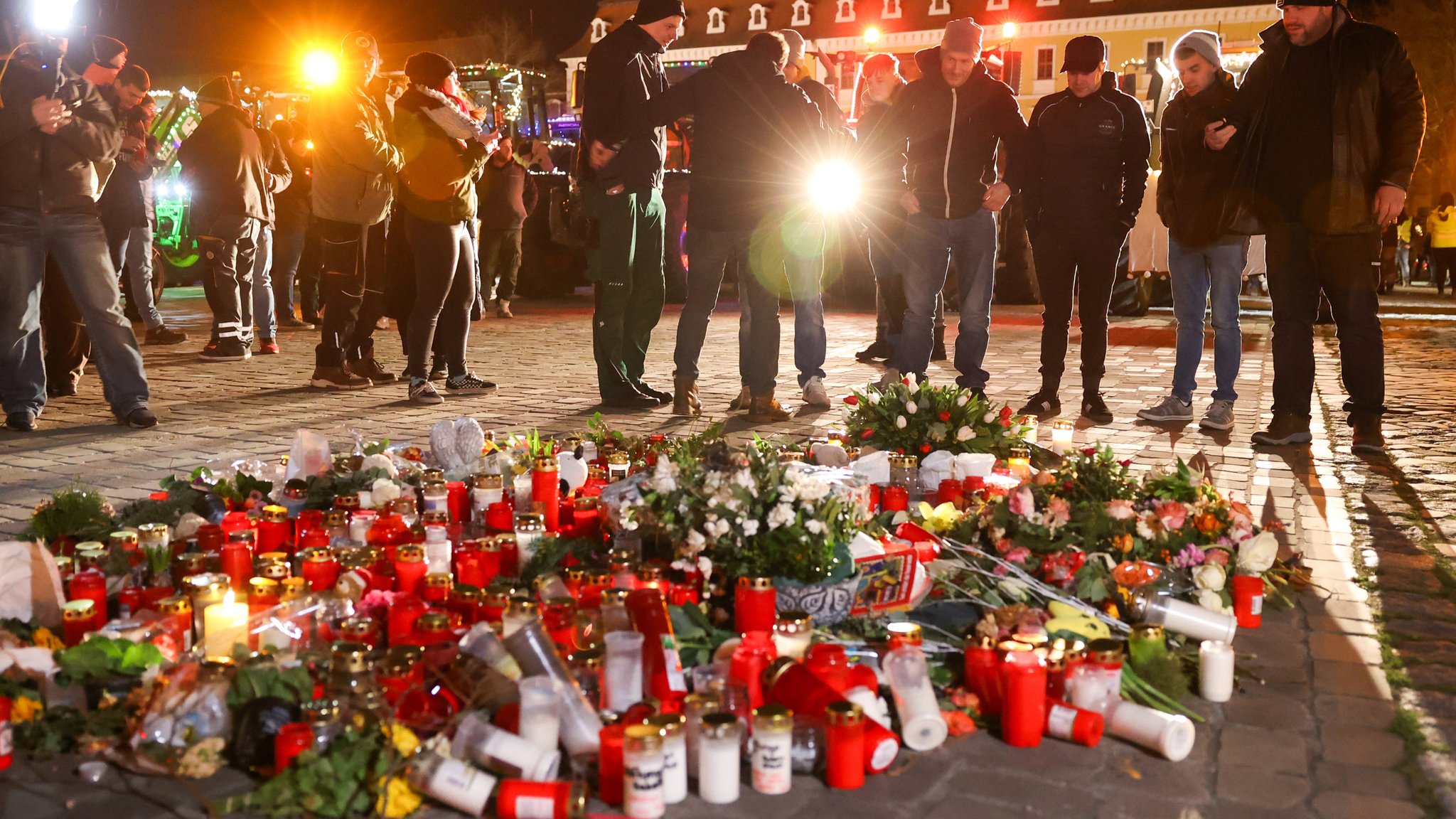 Teilnehmer der Lichterfahrt "Ein Funken Hoffnung für Magdeburg" legen Blumen auf dem Domplatz nieder (Bild vom 01.01.2025)