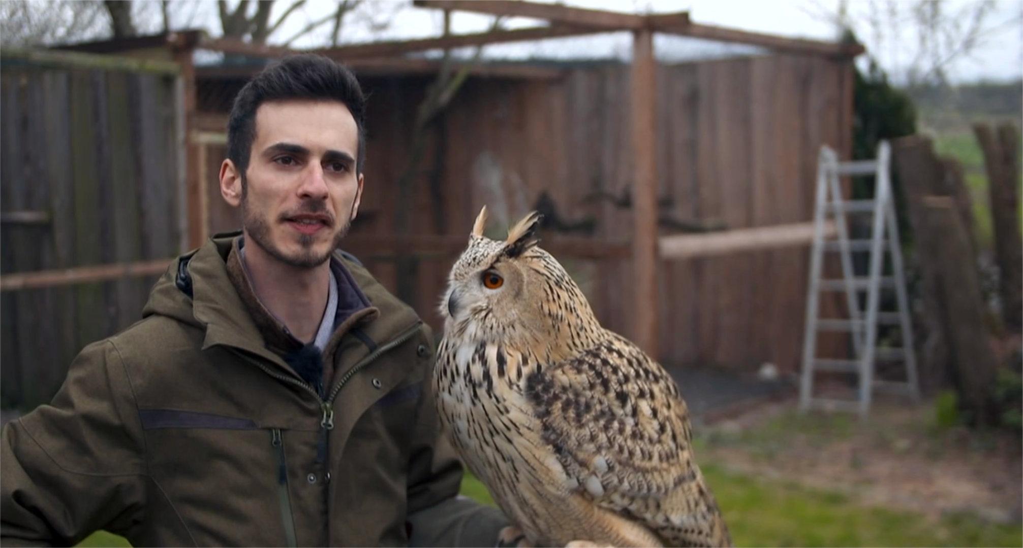 Danilo Batz mit einem Uhu auf dem Arm