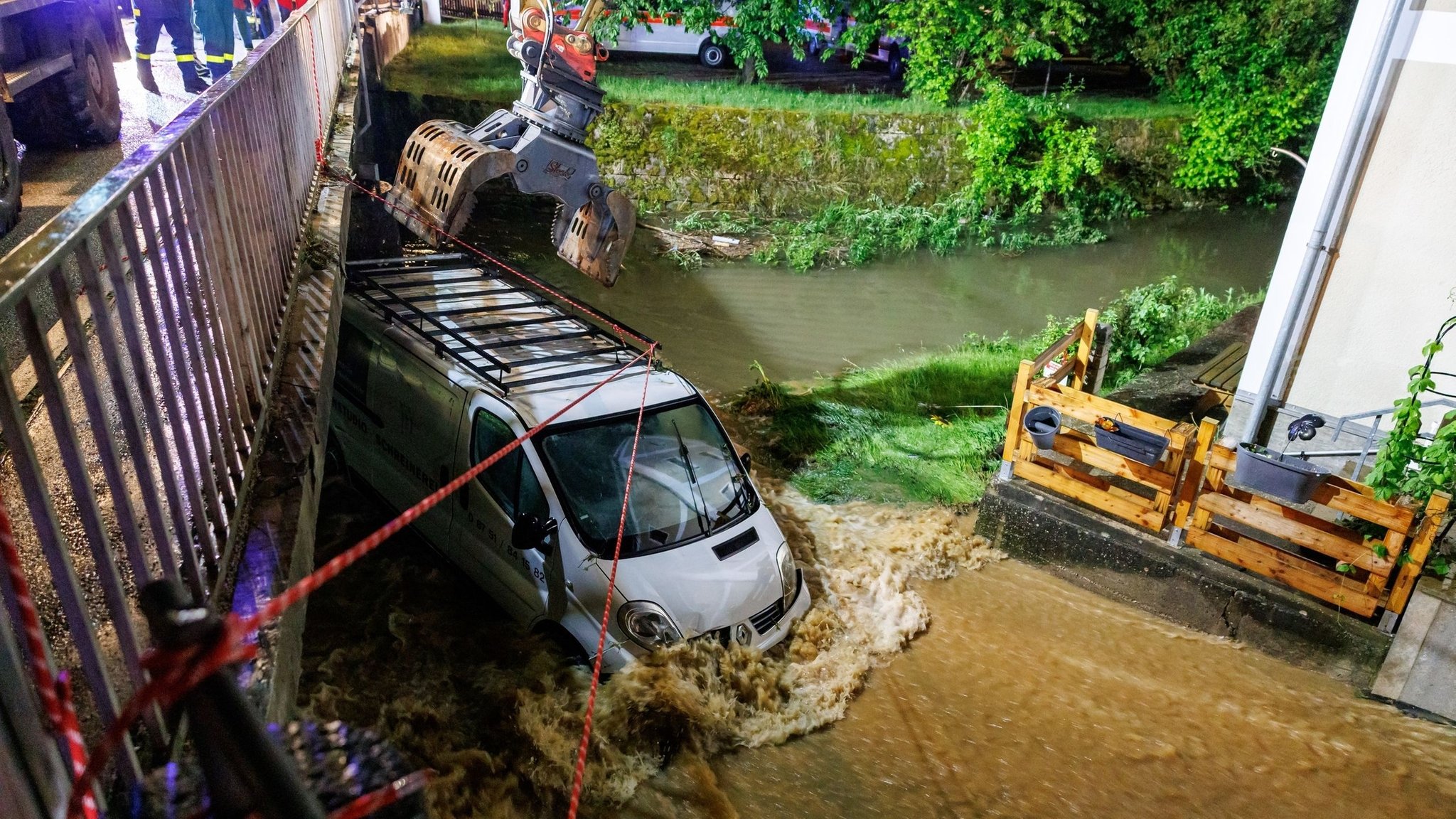 Mit schwerem Gerät werden vom Wasser mitgerissene Autos geborgen