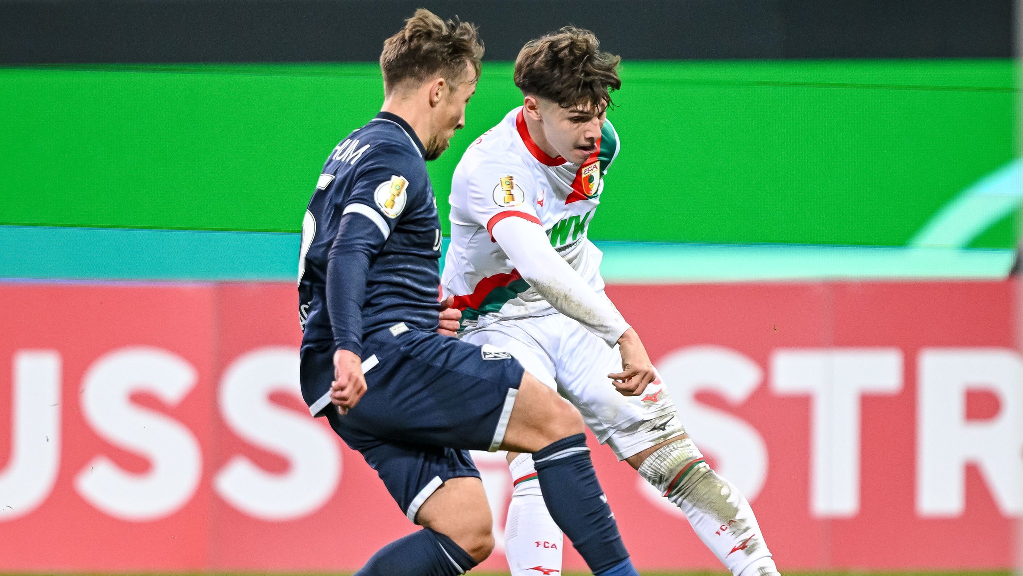 28.10.2025, Bayern, Augsburg: Fußball: DFB-Pokal, FC Augsburg - VfL Bochum, 2. Runde, WWK-Arena. Felix Passlack (l, VfL Bochum) in Aktion gegen Mert Kömür (FC Augsburg). Foto: Harry Langer/dpa - WICHTIGER HINWEIS: Gemäß den Vorgaben der DFL Deutsche Fußball Liga bzw. des DFB Deutscher Fußball-Bund ist es untersagt, in dem Stadion und/oder vom Spiel angefertigte Fotoaufnahmen in Form von Sequenzbildern und/oder videoähnlichen Fotostrecken zu verwerten bzw. verwerten zu lassen. +++ dpa-Bildfunk +++ | Bild: dpa-Bildfunk/Harry Langer 28.10.2025, Bayern, Augsburg: Fußball: DFB-Pokal, FC Augsburg - VfL Bochum, 2. Runde, WWK-Arena. Felix Passlack (l, VfL Bochum) in Aktion gegen Mert Kömür (FC Augsburg). Foto: Harry Langer/dpa - WICHTIGER HINWEIS: Gemäß den Vorgaben der DFL Deutsche Fußball Liga bzw. des DFB Deutscher Fußball-Bund ist es untersagt, in dem Stadion und/oder vom Spiel angefertigte Fotoaufnahmen in Form von Sequenzbildern und/oder videoähnlichen Fotostrecken zu verwerten bzw. verwerten zu lassen. +++ dpa-Bildfunk +++