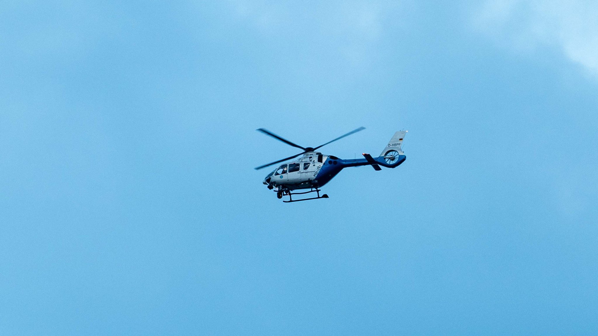 Ein Polizeihubschrauber überfliegt das Oktoberfest 2025 (Symbolbild).