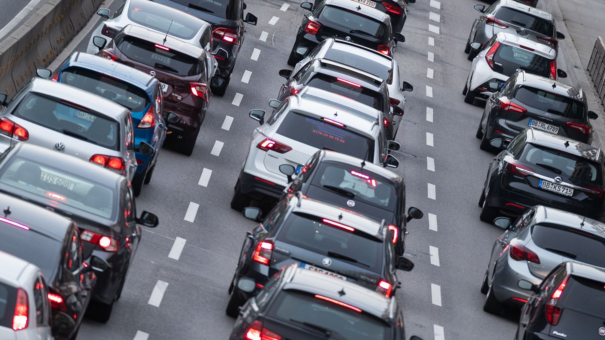 Autos stehen im Stau auf einer dreispurigen Straße.