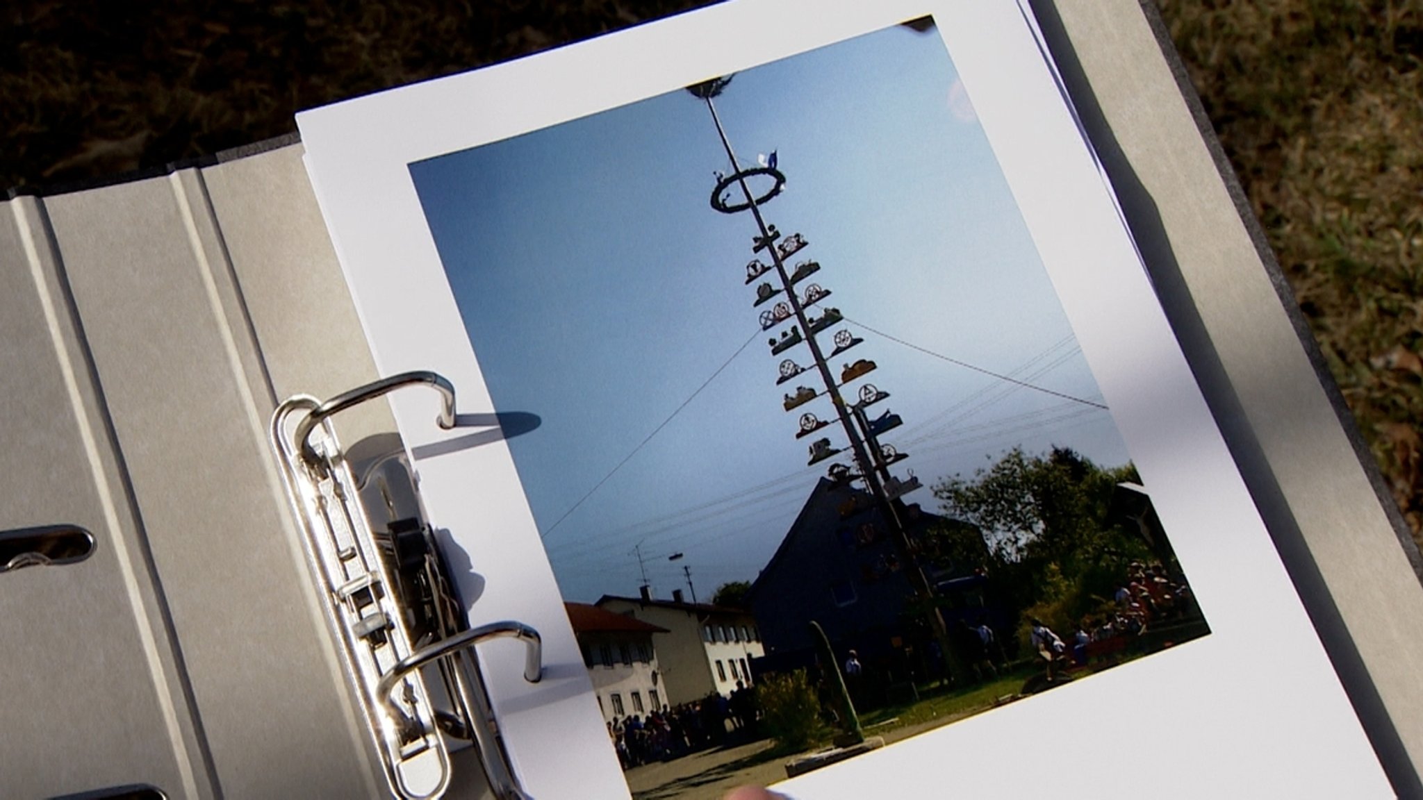 In einem Ordner ist ein Foto vom Maibaum in Altusried zu sehen