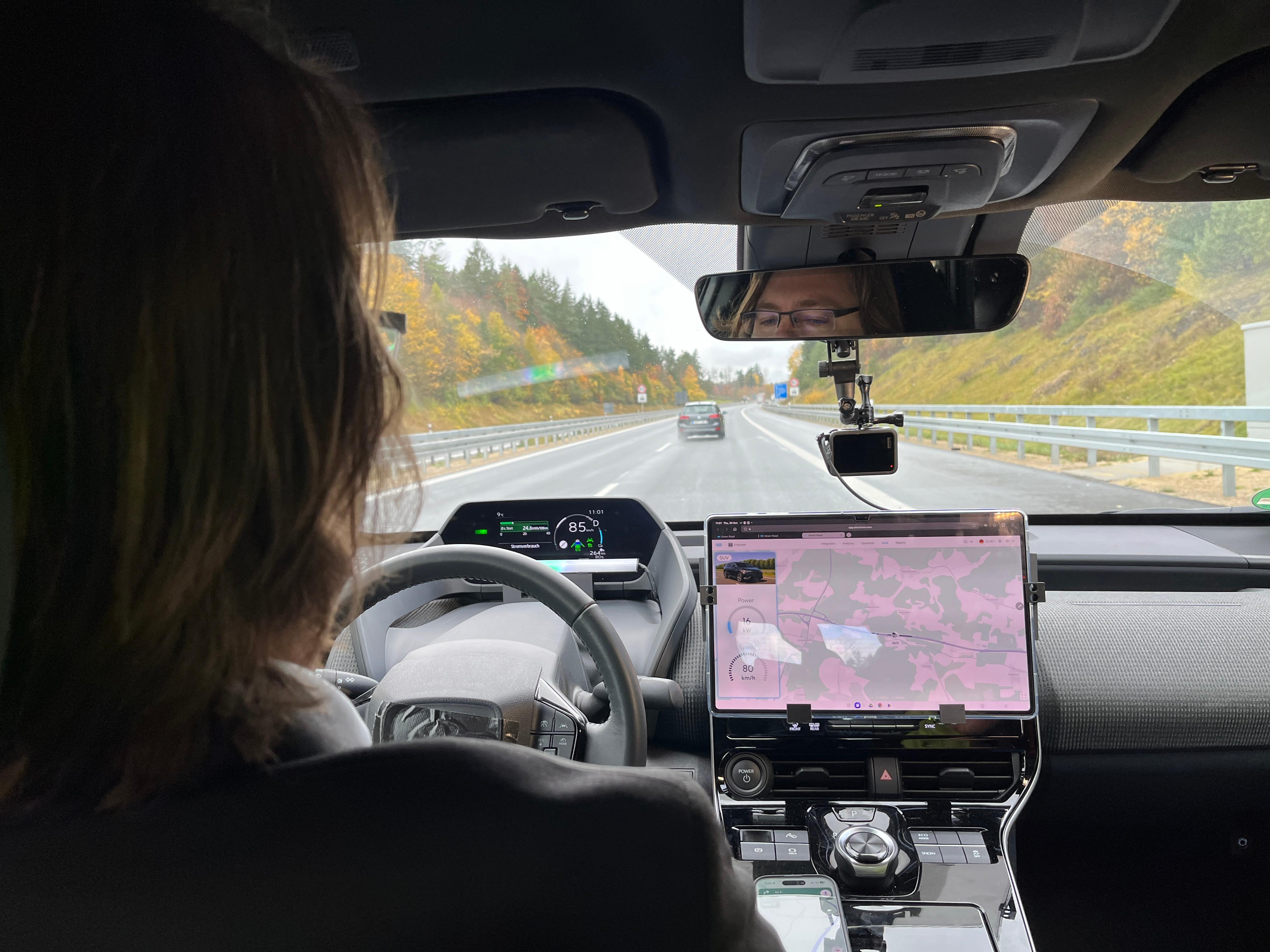 Entwickler Andreas Wendt hat neben seinem Lenkrad ein Tablet, das den Ladevorgang auf der Induktiven Strecke - auf der A6 bei Amberg - anzeigt.
