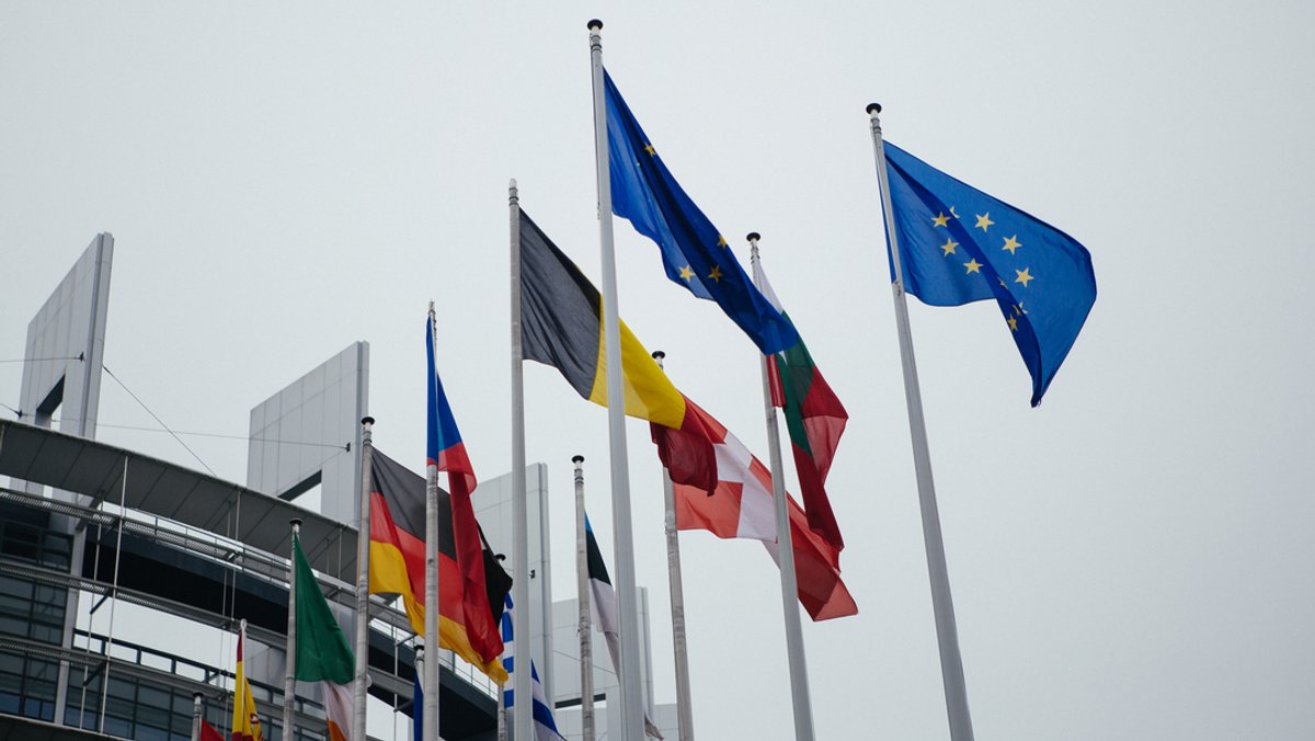 Flaggen wehen vor dem Europäischen Parlament. 