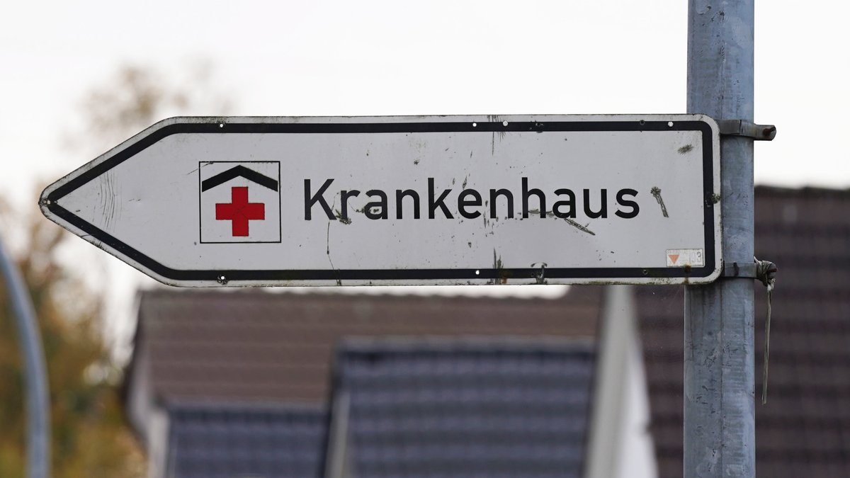 Ein Hinweisschild mit der Aufschrift "Krankenhaus" weist an einer Straße den Weg zu einer Klinik.