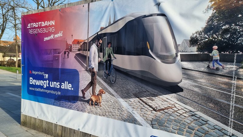 Plakatwand mit einer Darstellung der geplanten Straßenbahn | Bild: BR/Marcel Kehrer Plakatwand mit einer Darstellung der geplanten Straßenbahn